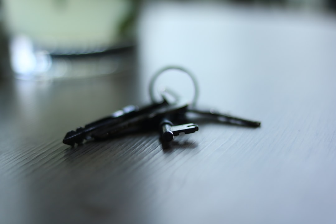 A set of house keys resting on a wooden table on a rainy day