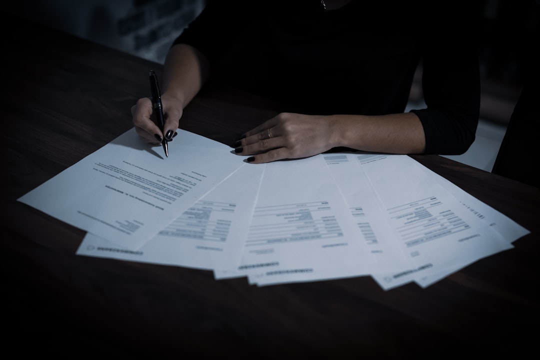 A seller reviewing a spread of listing forms and disclosures on a table